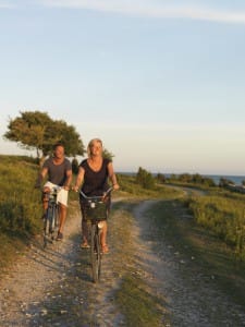 Fahrradtour in Schweden, 2 lachende Menschen auf Fahrrädern im Sonnenschein
